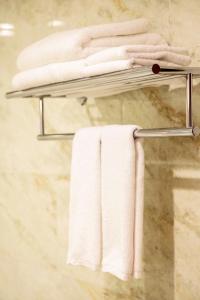 - un porte-serviettes dans la salle de bains pourvue de serviettes blanches dans l'établissement Minh Tam Phu Nhuan Hotel & Spa, à Hô-Chi-Minh-Ville