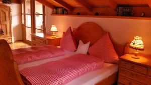 - une chambre avec 2 lits dotés d'oreillers rouges et blancs dans l'établissement Ferienhaus Hornauer, à Obertraubenbach