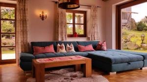 un soggiorno con divano blu e tavolo di Ferienhaus Hornauer a Obertraubenbach