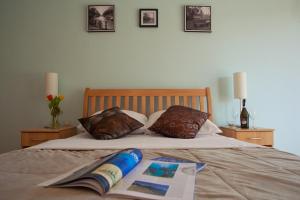 a bed with two pillows and a book on it at Apartments Bella Vista in Kamenari