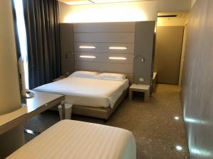 a small bedroom with two beds and a mirror at Best Western Plus Net Tower Hotel Padova in Padova