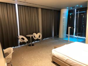 a bedroom with a bed and a table and chairs at Best Western Plus Net Tower Hotel Padova in Padova