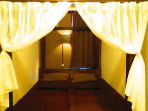 uma cama num quarto com uma janela com cortinas em Stella Resort em Naha