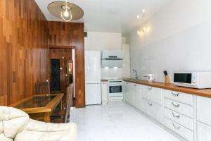 a kitchen with white appliances and wooden cabinets at New building near Arena City Lesi Ukrainky 7a in Kyiv