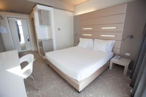 a small bedroom with a white bed and a chair at Best Western Plus Net Tower Hotel Padova in Padova