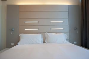 a bed with two white pillows and a headboard at Best Western Plus Net Tower Hotel Padova in Padova