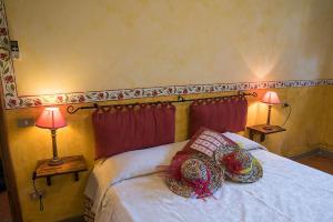 a bedroom with a bed with pillows and two lamps at Agriturismo Fattoria Sant'Appiano in Barberino di Val dʼElsa