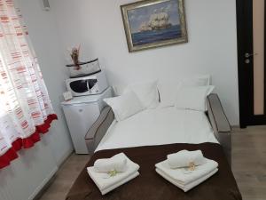 ピアトラ・ネアムツにあるApartament Confortのベッドルーム1室(白いベッド1台、タオル付)