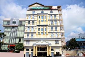 un edificio blanco alto con un cartel encima en Minh Tam Phu Nhuan Hotel & Spa, en Ho Chi Minh