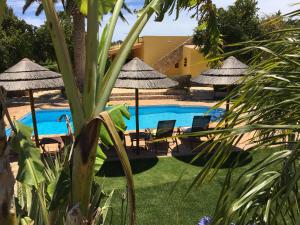 a pool with chairs and umbrellas next to a resort at Casa Paula Villas - Private Heated Pool for Each House in Lagos +61 photos