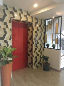 pasillo con puerta roja y pared geométrica en Bangkok Saran Poshtel, en Bangkok