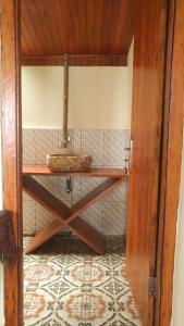 a bathroom with a sink on a tiled wall at Panorama Backpackers in Bunaken