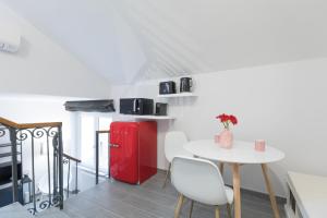 een keuken met een witte tafel en een rode koelkast bij Quiet pied a terre with terrace in Borgo Pio in Rome +20 foto's