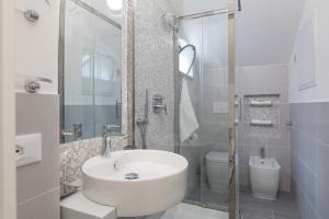 een witte badkamer met een wastafel en een toilet bij Quiet pied a terre with terrace in Borgo Pio in Rome