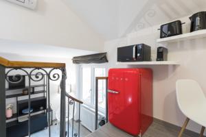 frigorifero rosso in una stanza con scaffali di Quiet pied a terre with terrace in Borgo Pio a Roma