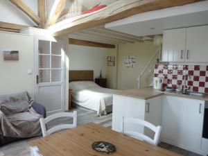 a room with a kitchen and a bedroom with a bed at L'Etable d'Orgerus in Orgerus