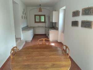 une salle à manger avec une table en bois et une cuisine dans l'établissement La Corte del Conte, à Rovereto