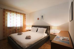 a bedroom with a bed and a table and a window at Vrata Jadrana in Rijeka