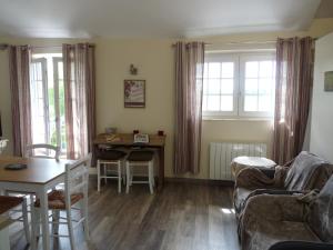 a living room with a couch and a table at L'Etable d'Orgerus in Orgerus