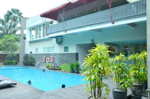 a swimming pool in front of a building at Grand Cakra Hotel Malang in Malang
