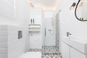 a white bathroom with a shower and a sink at The Old Town View in Kraków