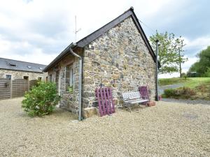 una casa de piedra con un banco delante en Breton stone house in Saint Gilles les Bois, en Saint-Gilles-les-Bois