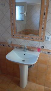 un lavandino bianco in un bagno con specchio di Villa Elli ad Ammouliani