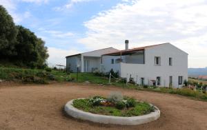 a white house on top of a dirt road at BnB Anacleto in Bassacutena