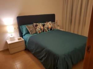 グアルダマル・デル・セグラにあるApartamento Mediterraneo Guardamarのベッドルーム1室(青いシーツと枕のベッド1台付)