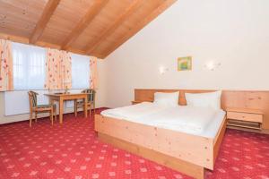 a bedroom with a bed and a table and a desk at Zum Kirchenwirt in Neukirchen vorm Wald