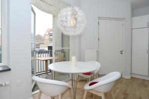 een witte eetkamer met een witte tafel en stoelen bij Sønderborg City Apartments in Sønderborg