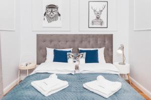 a bedroom with a bed with blue and white pillows at The Old Town View in Kraków
