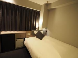 een hotelkamer met 2 bedden en een raam bij Haneda Inn in Tokyo