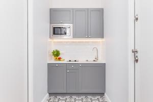 a small kitchen with a sink and a microwave at The Old Town View in Kraków