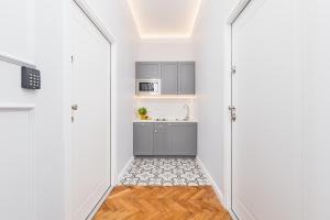 a kitchen with white walls and a door leading into a hallway at The Old Town View in Kraków +20 photos