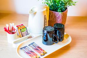 a tray with two mugs and a potted plant at Höfn Inn Guesthouse in Höfn