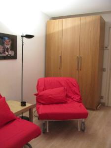a room with a red chair and a cabinet at Appartamenti Fronte Piste - Appartamentiflarida Foppolo in Foppolo
