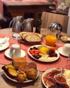 La Casona de Suesa في Suesa: طاولة مع أطباق من طعام الإفطار وعصير البرتقال