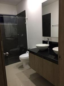 a bathroom with two sinks and a toilet and a shower at luxuriuso apartament in Cartagena de Indias