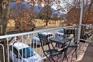 a balcony with a table and chairs and a car at Red Mountain House in Clarens