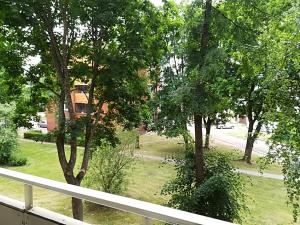 einen Balkon mit Blick auf einen Garten mit Bäumen in der Unterkunft Amber apartamentai in Druskininkai