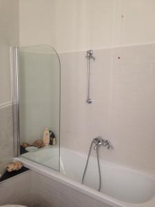 a bathroom with a tub with a shower and a mirror at Lavagna Uno in Genoa