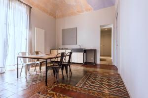 una cucina e una sala da pranzo con tavolo e sedie di Il Coro delle Nuvole a Catania