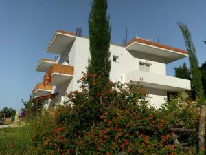 a white building with flowers in front of it at Penelope's Rooms in Dhërmi