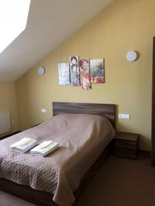 キーウにあるНа Бортуのベッドルーム1室(壁に絵画が飾られたベッド1台付)