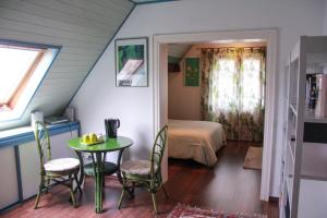 um quarto com uma mesa e cadeiras e um quarto em Chambres D'hotes Du Vignoble em Riquewihr