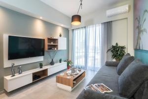 ハニア・タウンにあるMediterranean Luxury Apartmentのリビングルーム(グレーのソファ、薄型テレビ付)