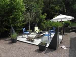 a patio with a table and chairs and an umbrella at Le presbytère de Brectouville in Brectouville +6 photos