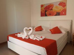 two swans sitting on a bed in a bedroom at B&B Fior di Mare in Porto Cesareo