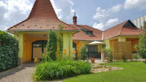 a yellow house with a red roof at Gardenia Apartman in Esztergom
